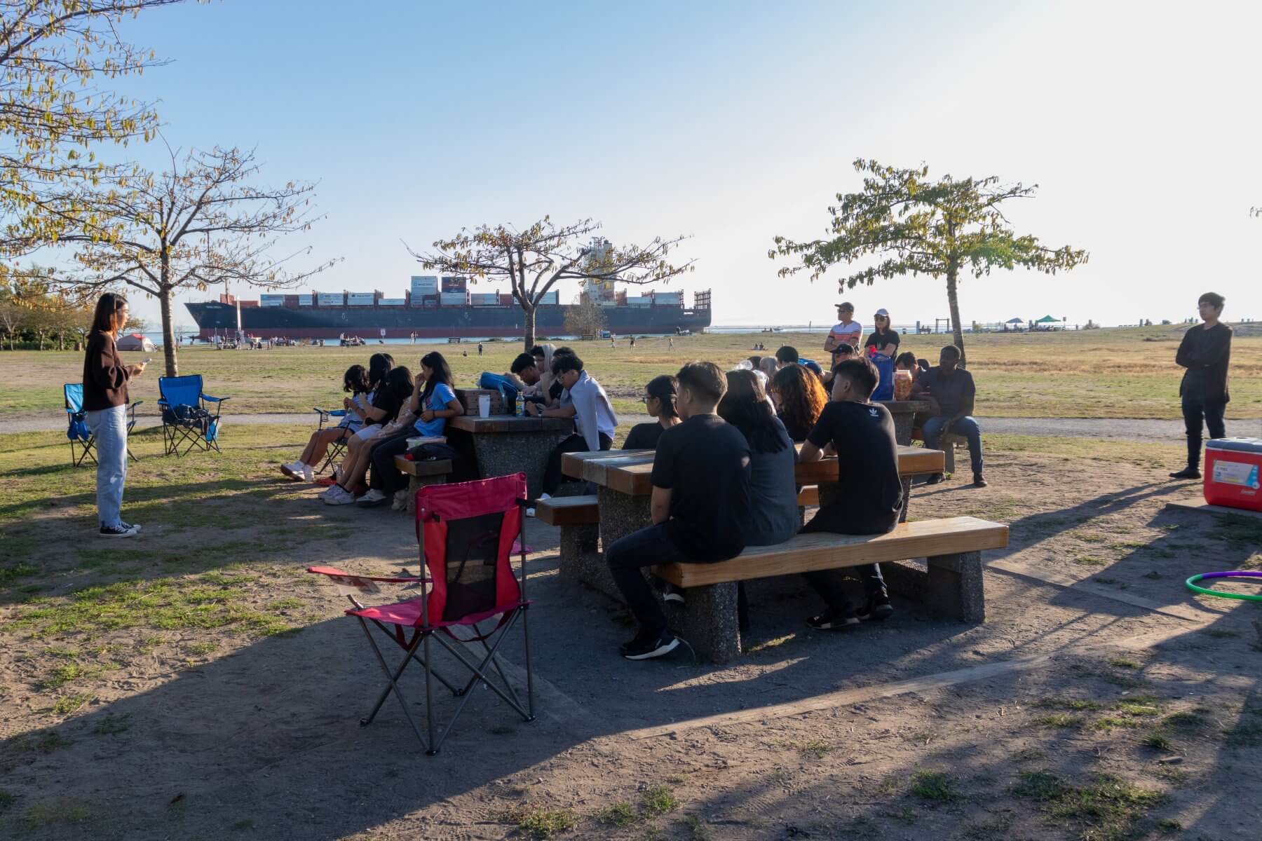 Youth group listening to a Bible talk in a field