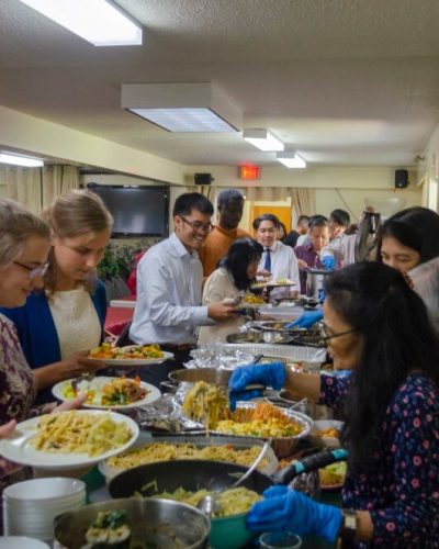 Members being served food during the potluck