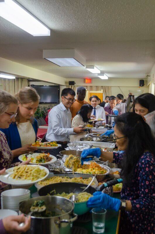 Members being served food during the potluck