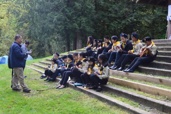 Pathfinders sitting outside practicing their ukelele performance