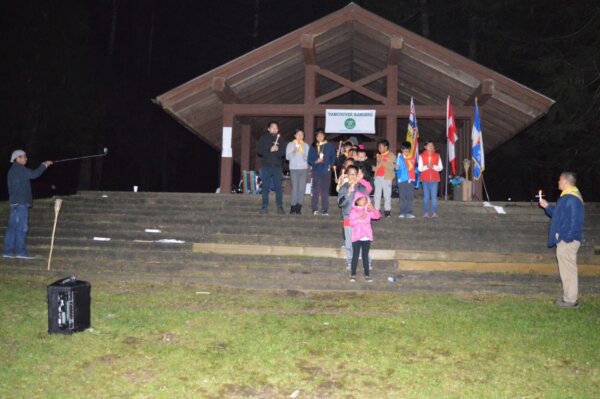 Pathfinders posing for a photo with candles at night