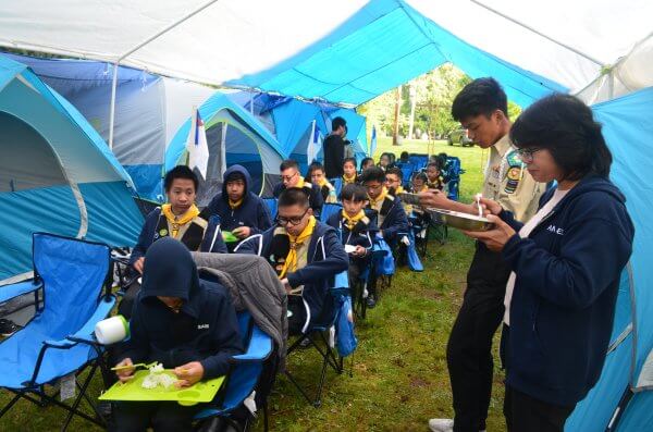 Pathfinders enjoying a breakfast meal at the camp tent