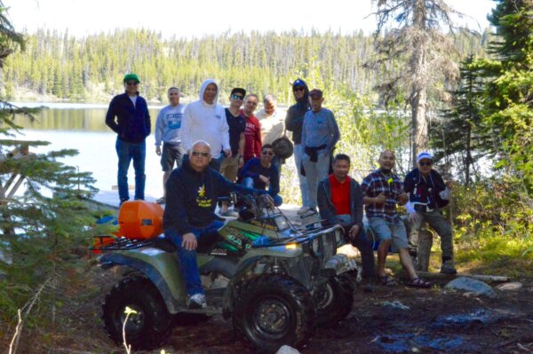 Men's outing posing with one of them on an ATV