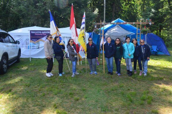 Pathfinder chaperones posing for a group photo with the group flags