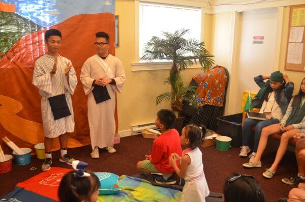 Two boys giving a Bible lesson to children during Vacation Bible School