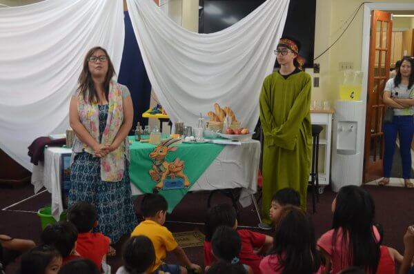 Woman and boy presenting a Bible story to children during Vacation Bible School