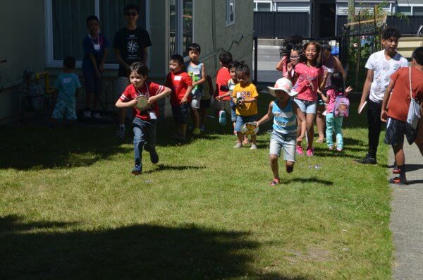 Two kids run to place their plate on a tic-tac-board