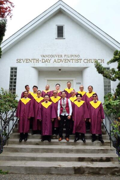 Men's choir standing all together for a photo outside the VanFil church